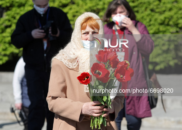 A woman carries flowers to the Monument of Eternal Glory on the Tomb of the Unknown Soldier, during the Victory Day celebration amid the Cov...