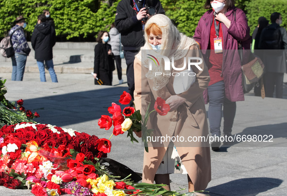 A woman lays flowers to the Monument of Eternal Glory on the Tomb of the Unknown Soldier, during the Victory Day celebration amid the Covid-...