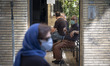 An Iranian elderly man wearing a protective face mask looks on as he sits in a heath cente...