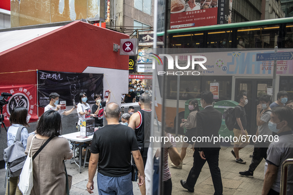 People walk pass a booth for the June 4 Vigil in Hong Kong, Sunday, May 9, 2021. The Hong Kong Alliance in Support of Patriotic Democratic M...