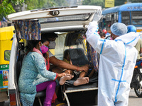 A family waits inside an ambulance with a patient who tested positive for COVID-19 ,for admission at a hospital in Kolkata , India , on 10 M...