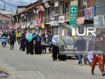 People with masks walk through a crowded area ahead of Muslim Festival Eid-Ul-Fitr in Sopore, District Baramulla, Jammu and Kashmir, India o...