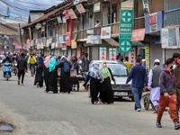 People with masks walk through a crowded area ahead of Muslim Festival Eid-Ul-Fitr in Sopore, District Baramulla, Jammu and Kashmir, India o...