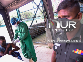 Military personnel  vaccinate a man  with a dose of the Chinese-made Sinopharm Covid-19 coronavirus vaccine in Colombo on May 11, 2021 (