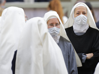 A group of nuns waits Pope Francis in the St. Damaso Courtyard at the Vatican for his weekly general audience, Wednesday, May 12, 2021.  (