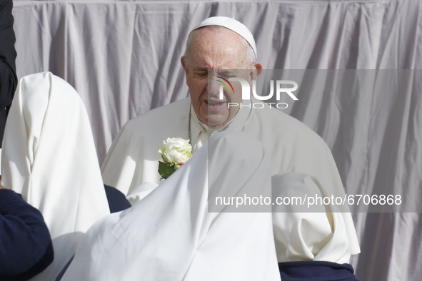 Nuns hand roses to Pope Francis as he arrives in the St. Damaso Courtyard at the Vatican for his weekly general audience, Wednesday, May 12,...