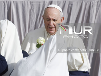 Nuns hand roses to Pope Francis as he arrives in the St. Damaso Courtyard at the Vatican for his weekly general audience, Wednesday, May 12,...