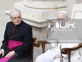 Pope Francis, right, begins the general audience in the St. Damaso Courtyard at the Vatican, Wednesday, May 12, 2021.  (
