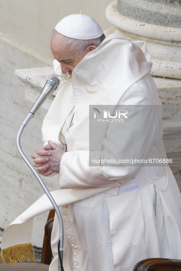 Pope Francis, right, prays in the St. Damaso Courtyard at the Vatican at the end of his weekly general audience, Wednesday, May 12, 2021.  