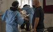 An Iranian elderly man wearing a protective face mask receives a dose of the China's Sinop...