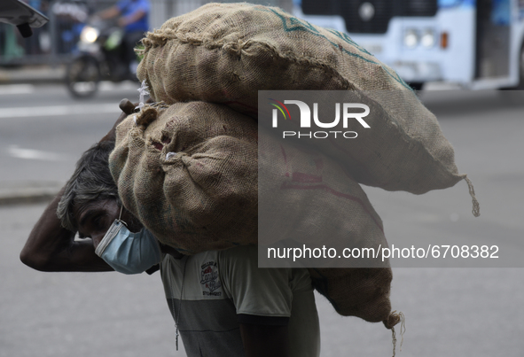 A man carrying heavy lorded onions near Colombo, Sri Lanka May 12, 2021 