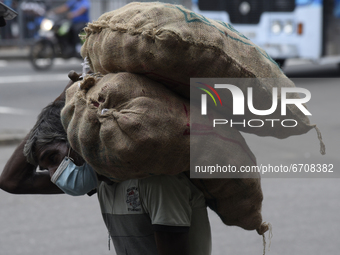 A man carrying heavy lorded onions near Colombo, Sri Lanka May 12, 2021 (