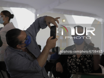 Adults between 50 and 59 years of age take pictures at the Benito Juarez Elementary School in the Cuauhtemoc district where they received th...