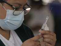 Medical personnel prepare syringes to inoculate adults between 50 and 59 years of age, who went to the Benito Juarez Elementary School in th...