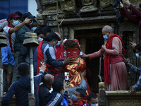 Nepalese Priest carrying idol Rato Machindranath towards the chariot on the first day of the longest chariot festival of Nepal during prohib...