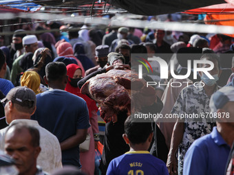 People are seen gathering a traditional market to buy meat, as a tradition before celebrating Eid al-Fitr called" Meugang" in Lhokseumawe, o...