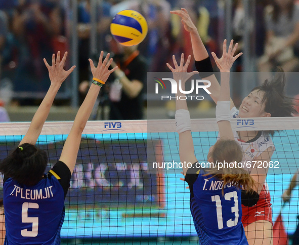 Sarina Koga (Top) of Japan spikes the ball as Thailand players attemp to block during their FIVB World Grand Prix intercontinental round mat...