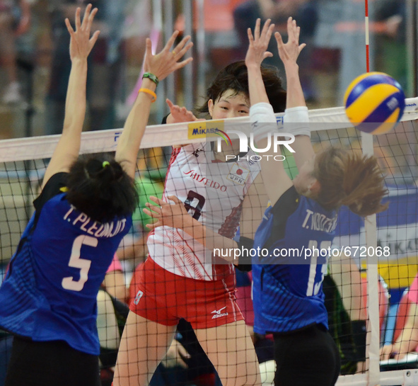 Sarina Koga (#8) of Japan spikes the ball as Thailand players attemp to block during their FIVB World Grand Prix intercontinental round matc...