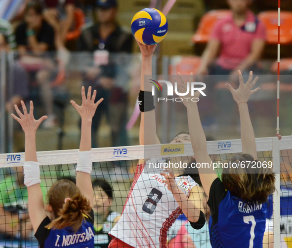 Sarina Koga (#8) of Japan spikes the ball as Thailand players attemp to block during their FIVB World Grand Prix intercontinental round matc...