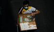 A vendor selling lottery tickets wear protective facemasks amid the new wave of COVID-19 c...