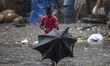 A man try to fix his umbrella during a  heavy rain in Dhaka streets in Bangladesh, on May...