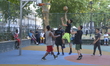 People participating in an amateur game of basketball, on Argyll Park's basketball courts,...
