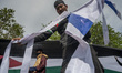 A protester tore an Israeli flag while participating in a solidarity demonstration for Pal...
