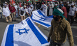 Protesters burn Israeli flags while participating in a solidarity action for Palestinians...