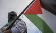 A protester carries a Palestinian flag while participating in a solidarity demonstration i...