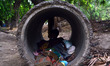 An indian child takes rest inside a sevage pipe,in Allahabad on July 5,2015.A new report b...