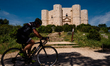 A cyclist walks in front of the Castel del Monte on the day of the reopening on May 22, 20...