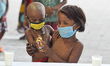A poor child takes a glass of milk and a packet of biscuits during a free glass of milk an...