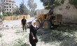 DAMASCUS, SYRIA - JULY 6, 2015-Woman running the rubble they crossed the street, which was...