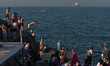 Young swimmers jump into the water at Forty Foot in Sandycove, Dublin, in fine sunny weath...