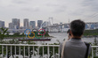 People take photo of the Olympic Rings displayed by the Odaiba Marine Park on the day mark...