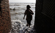 Mrs. Kasmi (60), checking her backyard during the tidal waves in Simonet village, northern...