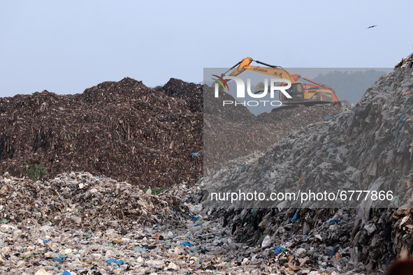 Municipality worker working using a excavator on a garbage-heap at Boragaon dumping site, on the eve of World Environment Day, in Guwahati,...