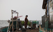 Villagers do their activity in their neighborhood surrounded by tidal floods in Bandengan...