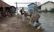 Villagers do their activity in their neighborhood surrounded by tidal floods in Bandengan...