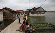 Villagers do their activity in their neighborhood surrounded by tidal floods in Bandengan...