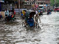 Vehicles try to driving through the waterlogged streets a waterlogged street after a heavy downpour in Dhaka, Bangladesh, on June 5, 2021. A...