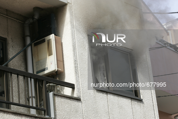 Firefighters try to contain a fire that broke out at residential area in Tokyo, July 8, 2015.  