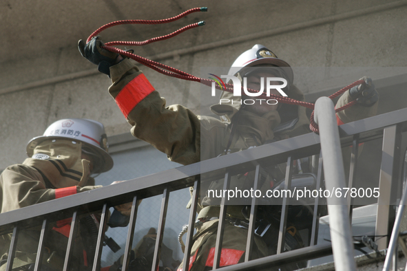 Firefighters try to contain a fire that broke out at residential area in Tokyo, July 8, 2015.  