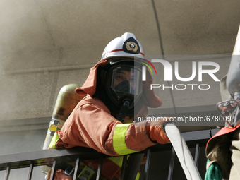 Firefighters try to contain a fire that broke out at residential area in Tokyo, July 8, 2015.  (
