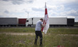 A man sticks the Belarusian flag into the ground during Belarusian opposition activists in...