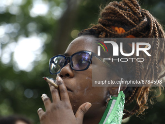 A person lights up a marijuana cigarette as New York City mayoral candidate Paperboy The Prince speaks and sings to a group of people near C...