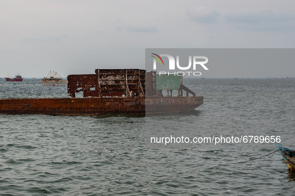 The wreckage of a ship has been dismantled and left at the shore in the north of Indonesia's capital Jakarta on 8 June 2021. As people aroun...