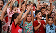Palestinian children cheer during a mental health support session  at the Beach refugee ca...