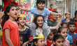 Palestinian children cheer during a mental health support session  at the Beach refugee ca...