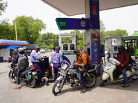 A fuel station attendant pumps petrol into a two wheeler during a protest against rising fuel prices of Petrol and Diesel, at a filling stat...